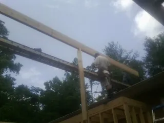 Carpenter setting a ridge beam over a new addition frame — Ice Dam Removal by Roofing Brothers in Levan