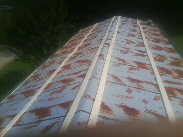 Rusted metal roof panels with new wood purlins before replacement — Storm Damage Roof Repair in Levan by Roofing Brothers