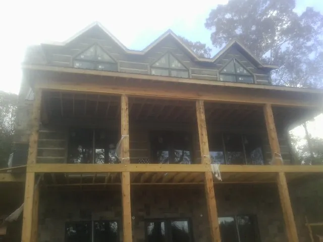 Dormers and porch framing on a large log home under construction — Roof Coating work by our crew in Levan