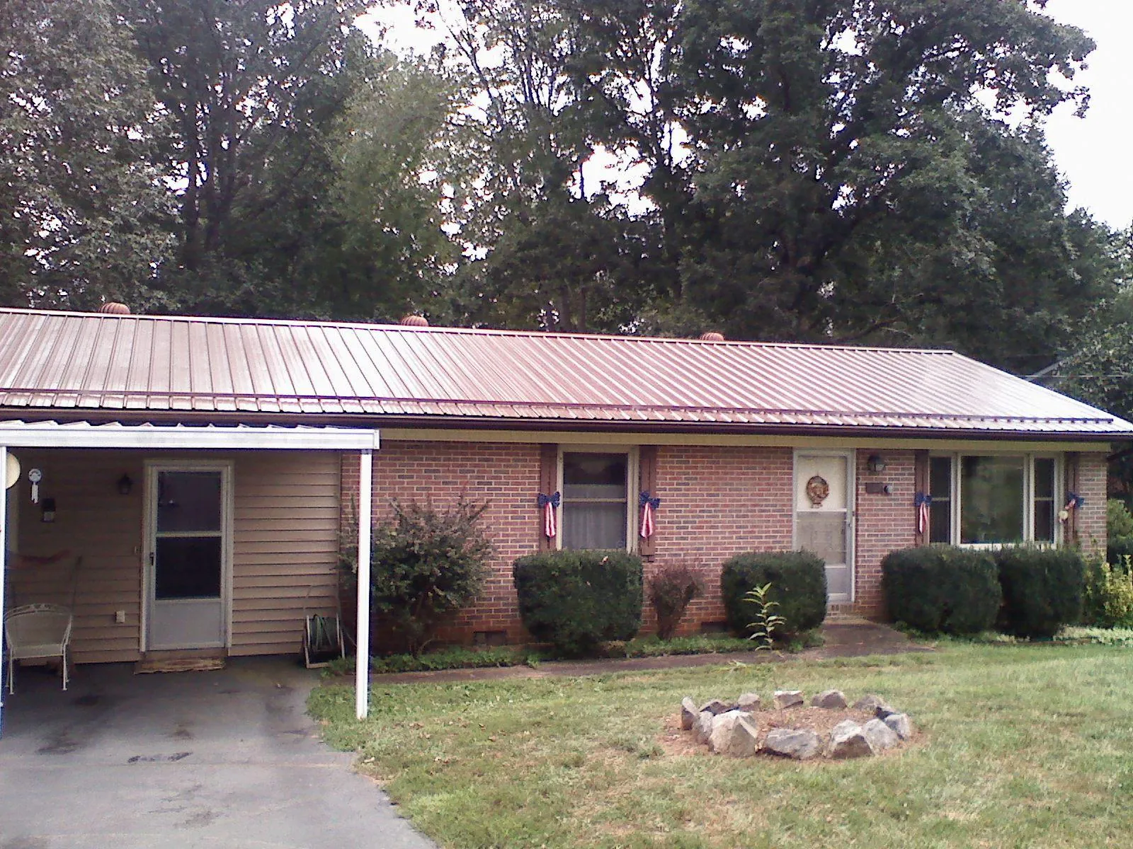 Bronze metal roof and carport on a brick ranch home — Roof Repair work by our crew in Levan