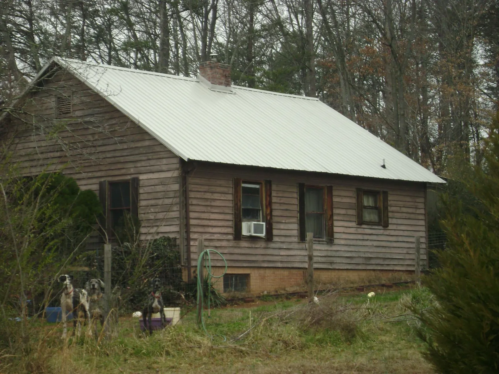 White metal roof on an old wood sided farmhouse, from a Metal Roof Installation job in Levan